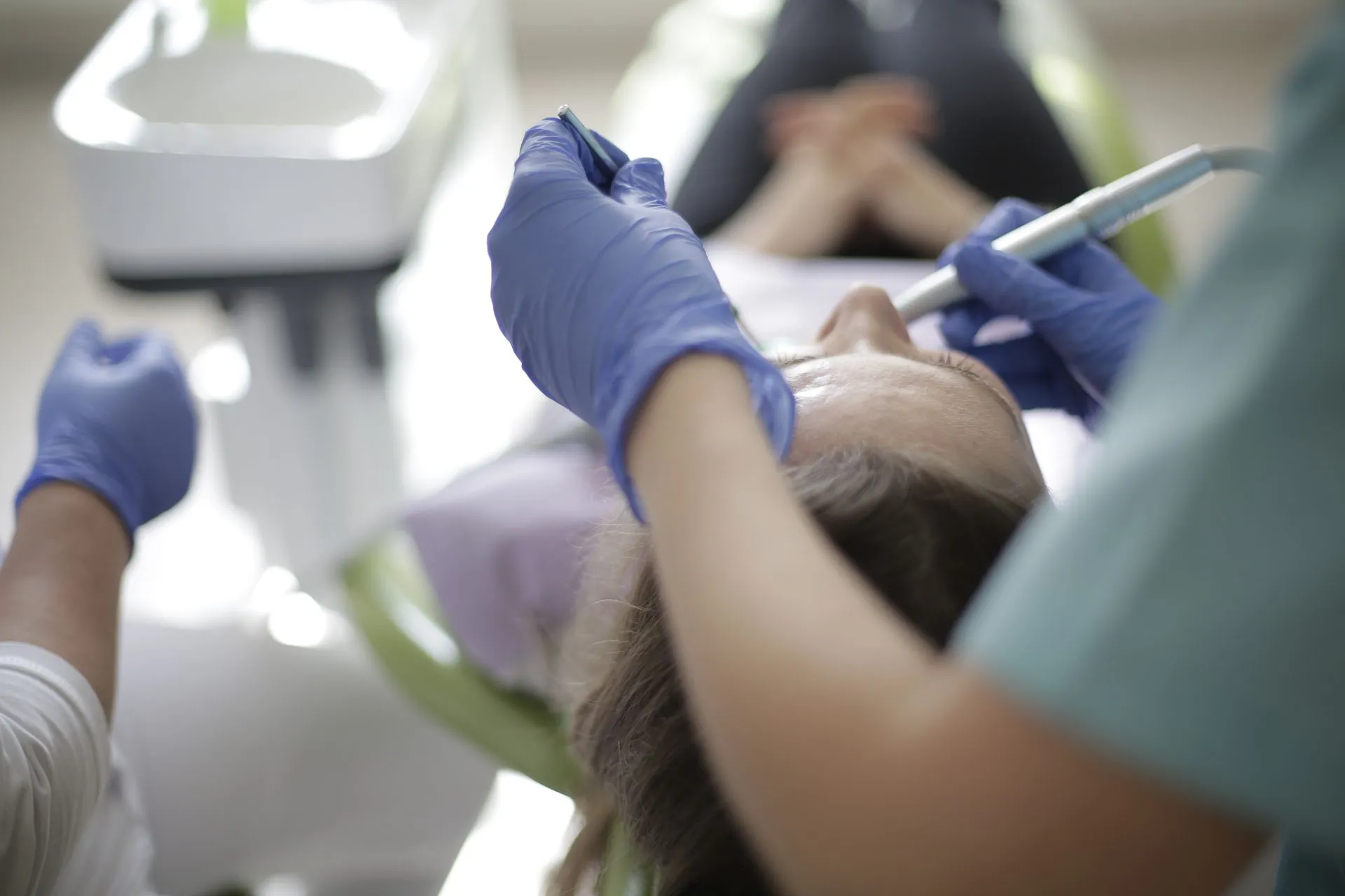 Odontóloga realizando un empaste a un paciente en el gabinete de Clínica Dental Vigoar
